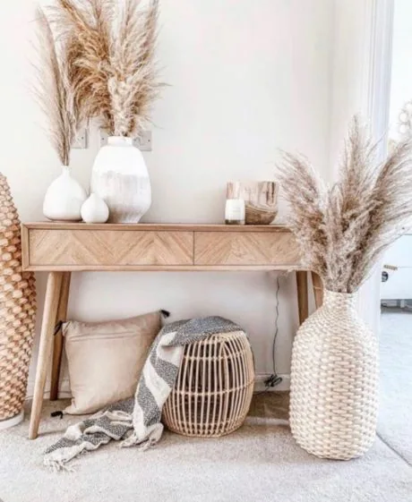 Konzolový stolek s pampovou trávou a proutěnými doplňky v boho stylu