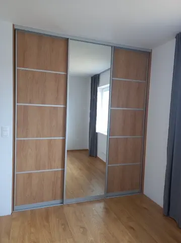 Posuvné dveře na míru do ložnice s kombinovanou výplní dveří v dekoru dub