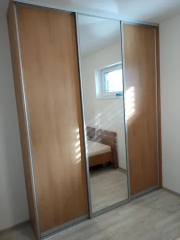 Šatní skříň na míru do ložnice, třídveřová s kombinovanou výplní dveří v dekoru buk