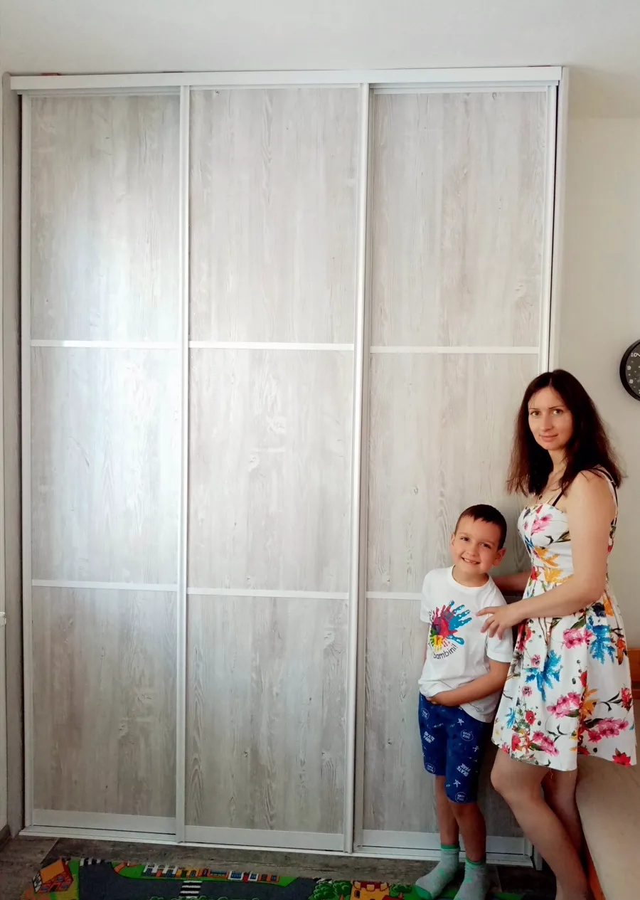 Vestavěná skříň do ložnice s třídílnými posuvnými dveřmi v dekoru dub